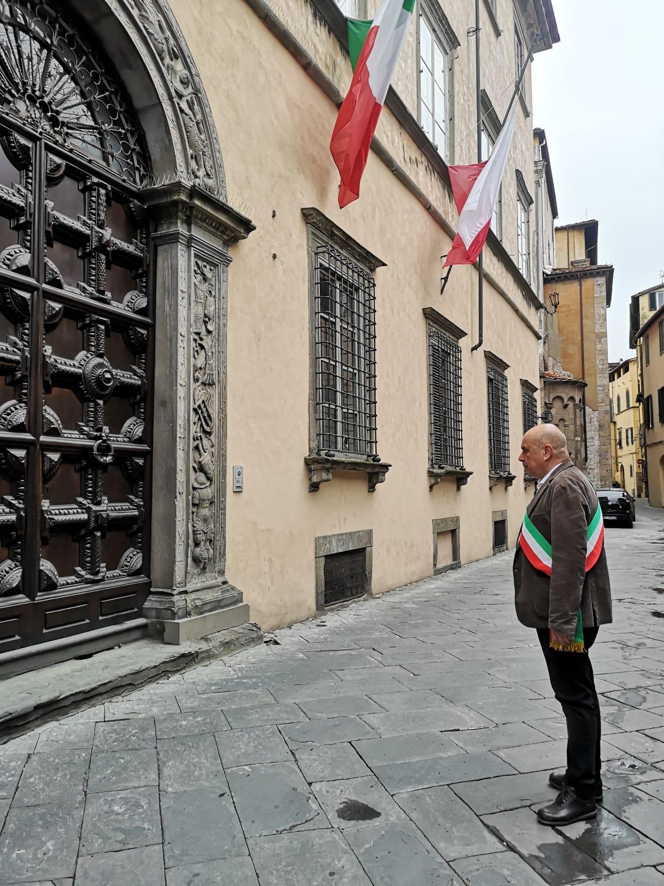 Anche a Lucca un minuto di silenzio per manifestare cordoglio  per le vittime della pandemia: l’assessore Ragghianti davanti alle  bandiere a lutto di Palazzo Orsetti